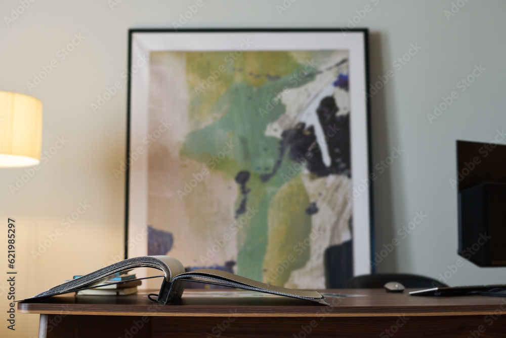 Workplace of designer of interior with abstract painting and open catalogue with samples of textiles for furniture or facing materials Workplace of designer of interior with abstract painting and open catalogue with samples of textiles for furniture or facing materials