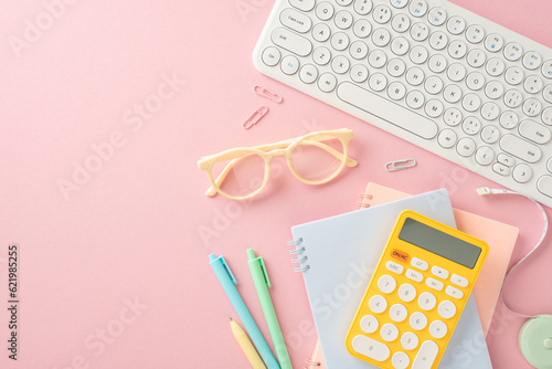 Papier peint Get back into the learning groove! Top view of notepads, pens, glasses, calculator, pc keyboard and other essentials on a pastel pink backdrop