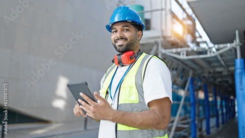 African american man builder smiling confident using touchpad at street