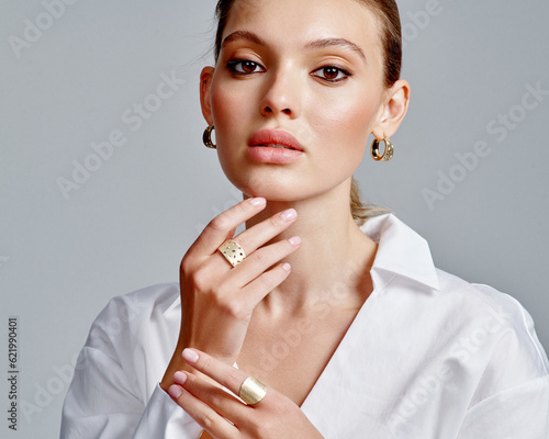 Close up portrait of a beautiful elegant woman with stylish jewelry on a white background. Beautiful girl with jewelry.