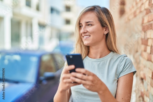 Young blonde woman smiling confident using smartphone at street © Krakenimages.com
