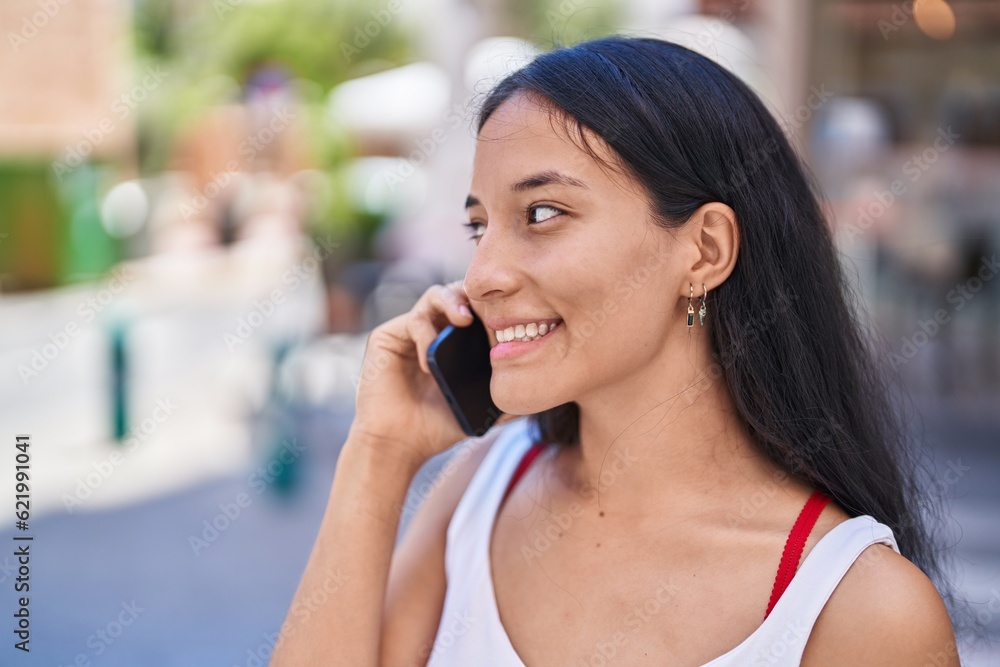 Young beautiful hispanic woman smiling confident talking on the smartphone at street Young beautiful hispanic woman smiling confident talking on the smartphone at street