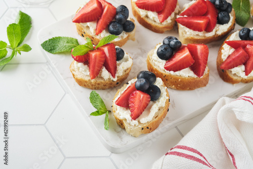 American flag sandwich with strawberries, blueberries, whipped sweet cream, soft cheese on toast bread. 4th of July American Independence Day food. Independence or Patriotic Day breakfast idea Mock up
