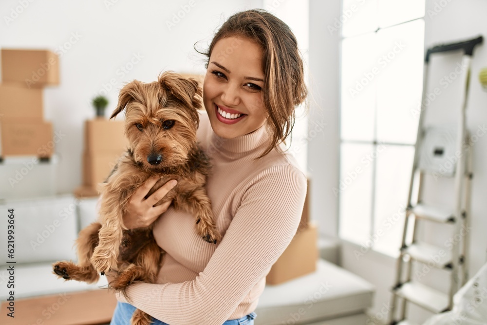 Young beautiful hispanic woman smiling confident hugging dog at new home Young beautiful hispanic woman smiling confident hugging dog at new home
