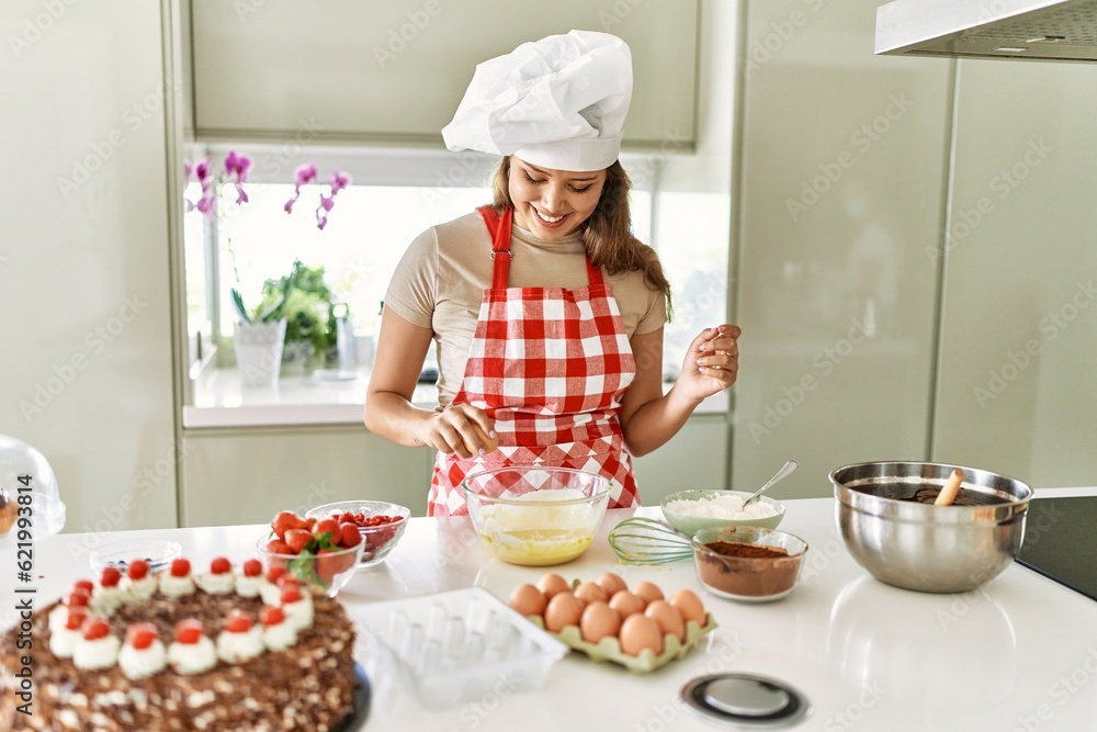 Young beautiful hispanic woman smiling confident breaking egg at the kitchen Young beautiful hispanic woman smiling confident breaking egg at the kitchen