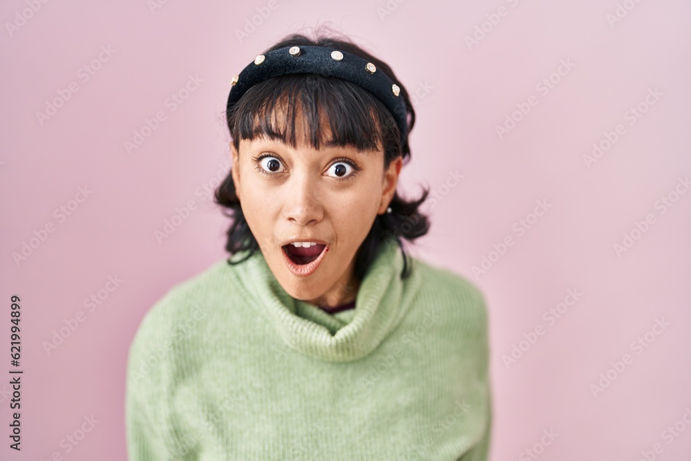 Young beautiful woman standing over pink background afraid and shocked with surprise and amazed expression, fear and excited face. Young beautiful woman standing over pink background afraid and shocked with surprise and amazed expression, fear and excited face.