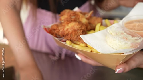 Serving chicken with french fries placing the sauce container on top