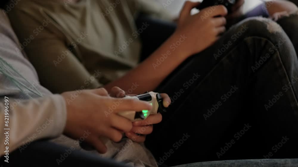kids hands with joysticks, two children siblings playing video game console while sitting at home, real people, leisure concept. kids hands with joysticks, two children siblings playing video game console while sitting at home, real people, leisure concept.