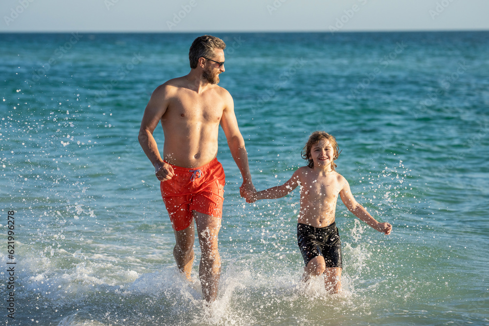 family moments between daddy and son at sea. Father son kid bonding relationship. daddy and son running in sea beach. Father son child bonding enjoying summer vacation. Fun filled summer getaway