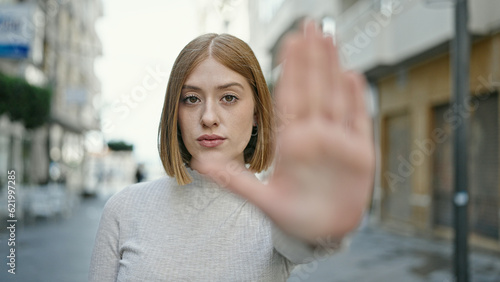 Young blonde woman doing stop gesture with hand at street © Krakenimages.com