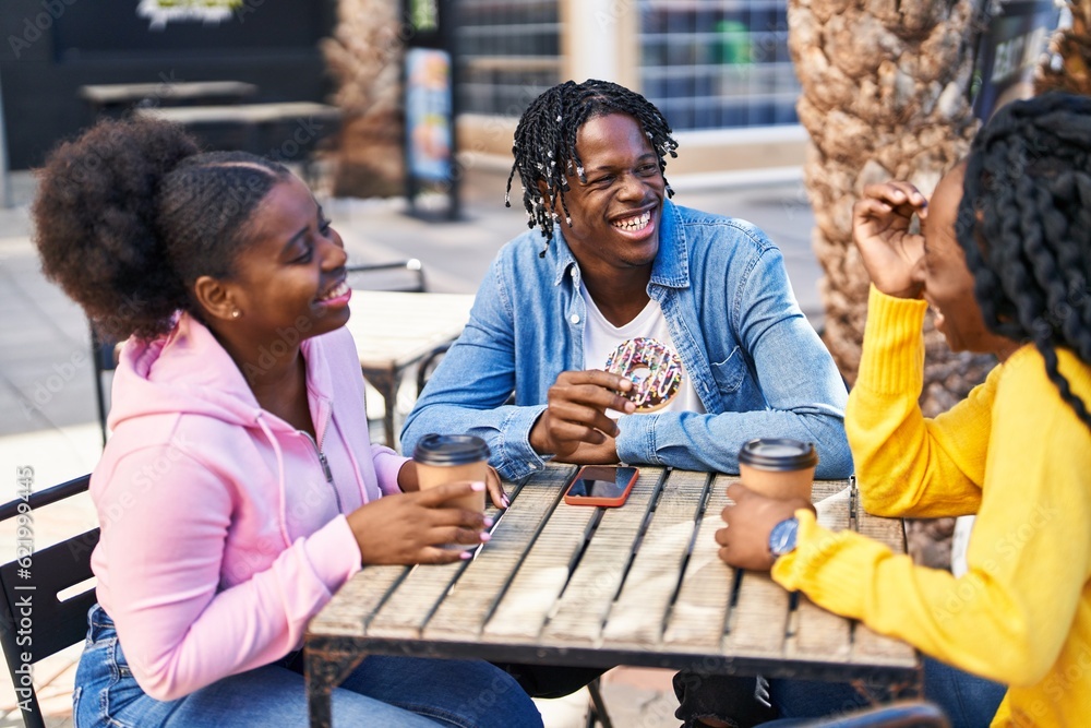 Fototapeta premium African american friends having breakfast sitting on table at coffee shop terrace