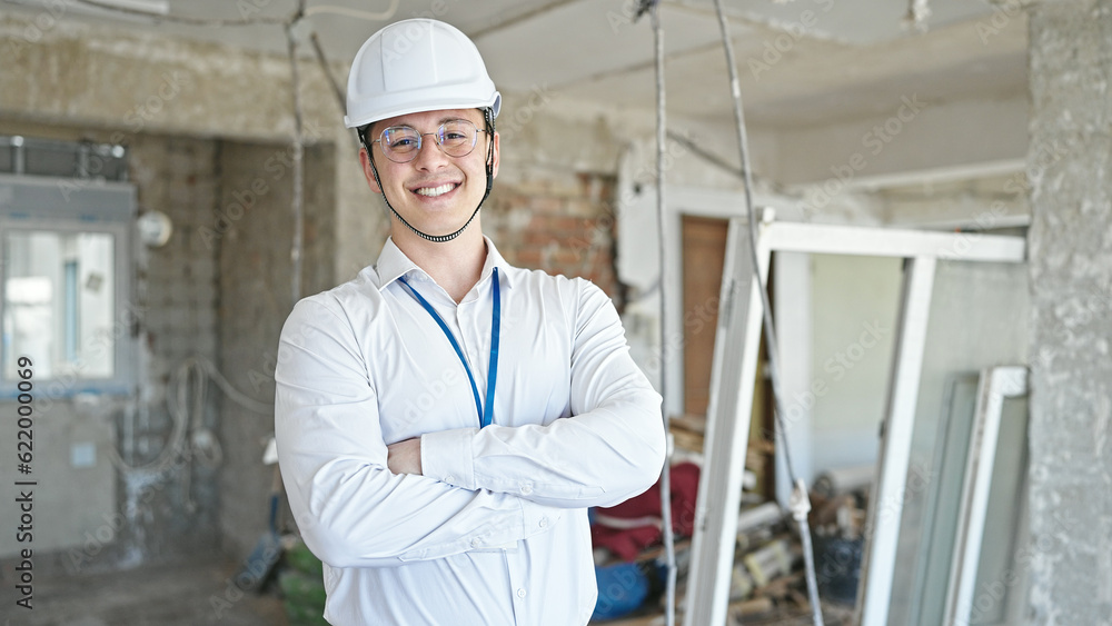 Young hispanic man architect smiling confident standing with arms crossed gesture at construction site Young hispanic man architect smiling confident standing with arms crossed gesture at construction site