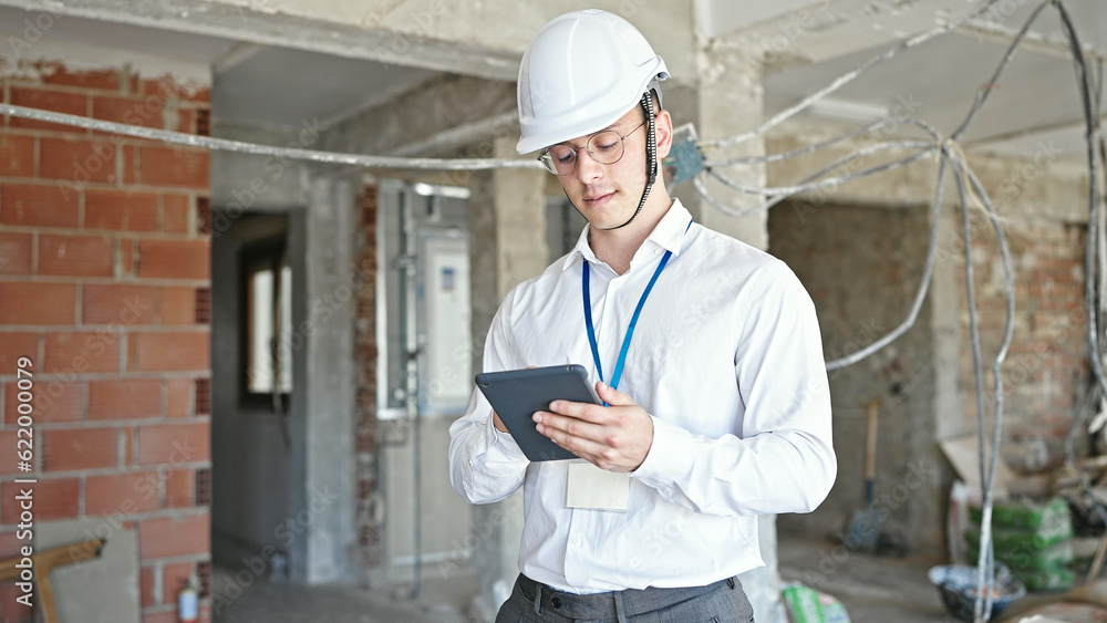 Young hispanic man architect standing with relaxed expression using touchpad at construction site Young hispanic man architect standing with relaxed expression using touchpad at construction site