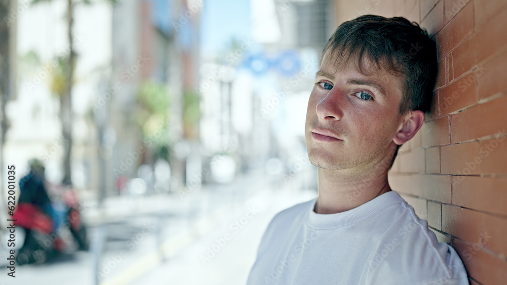 Young caucasian man standing with serious expression at street Young caucasian man standing with serious expression at street