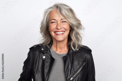 Portrait of happy senior woman in leather jacket smiling at camera.