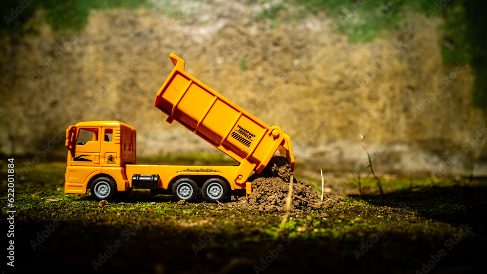 © 42L - South Minahasa, Indonesia : January 2023, a yellow dump truck toy transporting sand