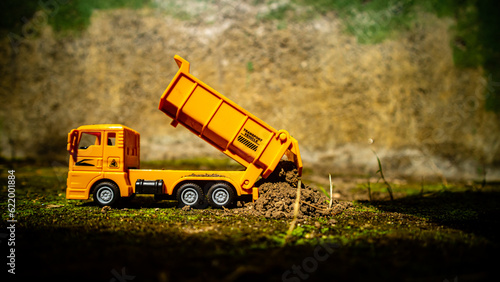 South Minahasa, Indonesia : January 2023, a yellow dump truck toy transporting sand