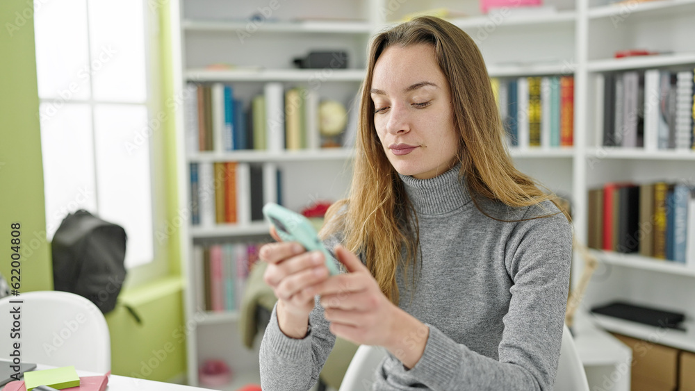 Young caucasian woman student using smartphone at library university Young caucasian woman student using smartphone at library university