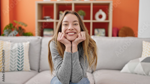 Young caucasian woman smiling confident sitting on sofa at home