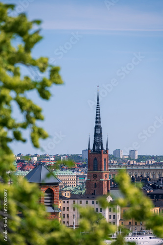 The spire of Riddarholmskyrkan church visible high above rooftops in Stockholm Sweden summertime