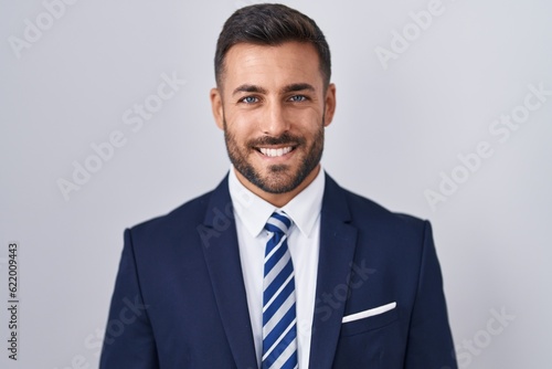 Handsome hispanic man wearing suit and tie with a happy and cool smile on face. lucky person.