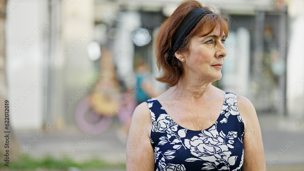 Middle age woman looking to the side with serious expression at street Middle age woman looking to the side with serious expression at street