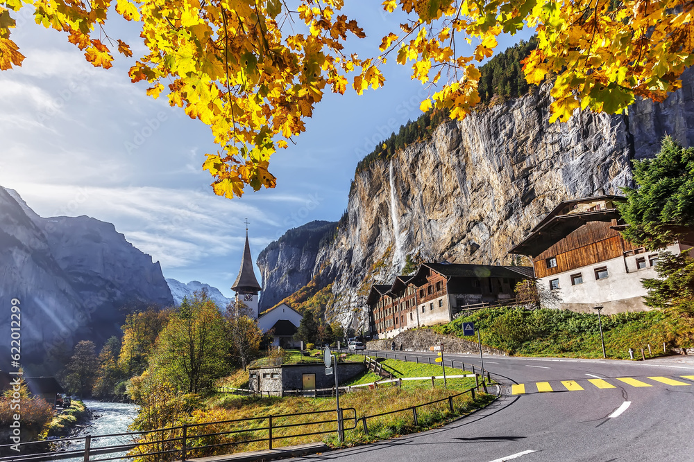 Wonderful autumn landscape. Lauterbrunnen village with awesome waterfall Staubbach and Swiss Alps in the background. Popular travel destination. Iconik location of Switzerland.