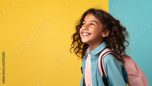 Portrait of smiling schoolgirl with school bag isolated on yellow background. Back to school concept. AI Generated.