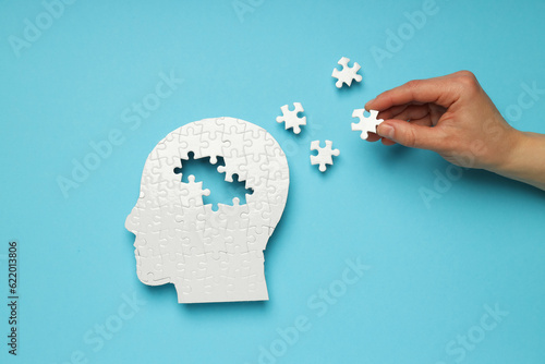 Puzzle head with missing elements on a blue background photo