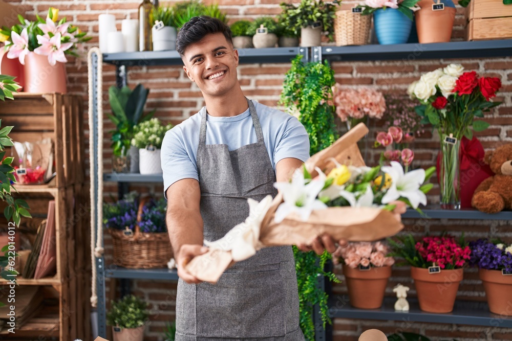 Young hispanic man florist holding bouquet of flowers at flower shop Young hispanic man florist holding bouquet of flowers at flower shop