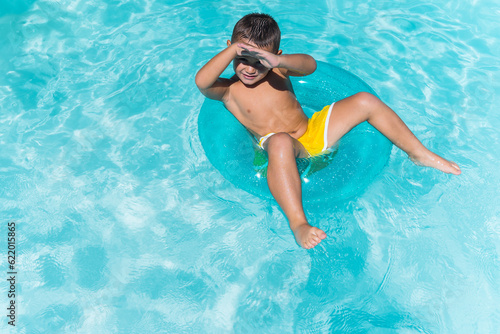 Child swimming in a pool with a large float