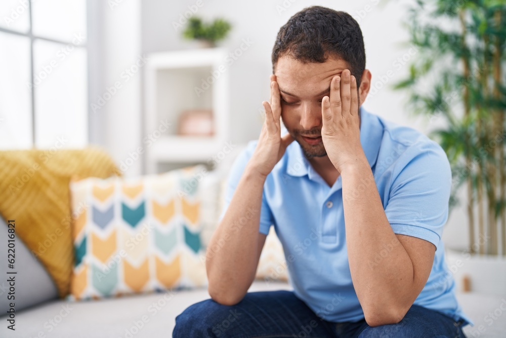 Young man stressed sitting on sofa at home Young man stressed sitting on sofa at home