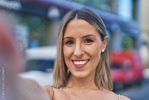 Young beautiful hispanic woman smiling confident making selfie by camera at street © Krakenimages.com