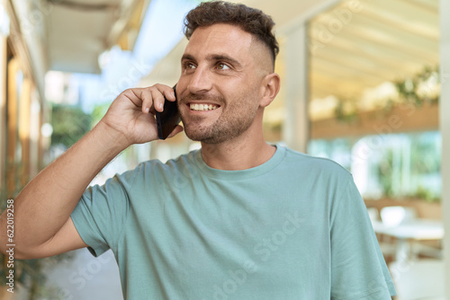 Young hispanic man smiling confident talking on the smartphone at coffee shop terrace