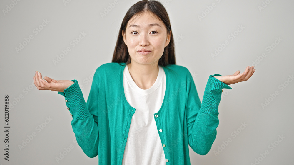 Young chinese woman standing clueless over isolated white background Young chinese woman standing clueless over isolated white background
