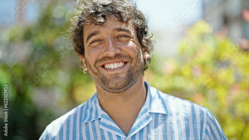 Young hispanic man smiling confident standing at park