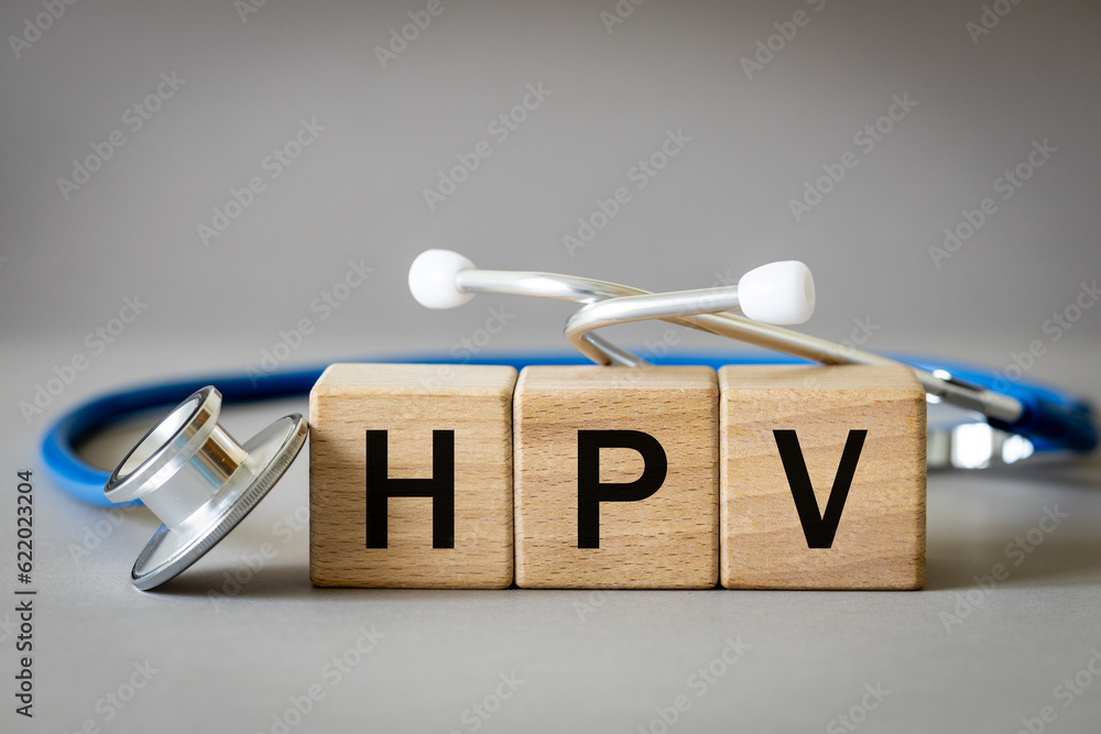 The doctor arranged the word HPV from wooden blocks, human papilloma virus, medical and health concept, medical stethoscope and gray background, close up