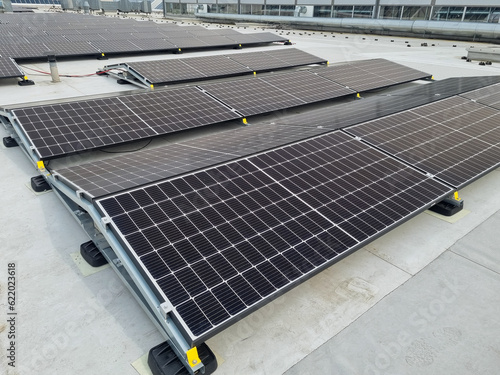 Solar panels covering the roof top of industrial building in the country side
