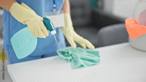 Young blonde woman professional cleaner cleaning table at the office