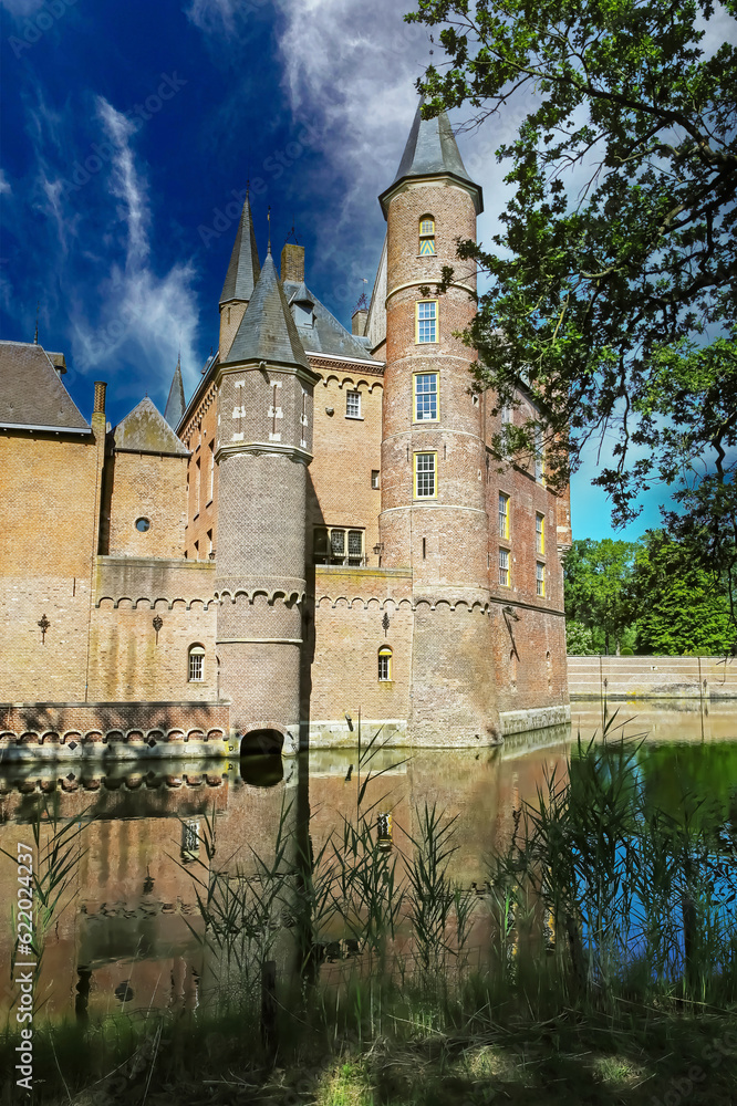 Beautiful idyllic scenic water moat with reflection of medieval castle wall and tower - Kasteel Heeswijk, Netherlands