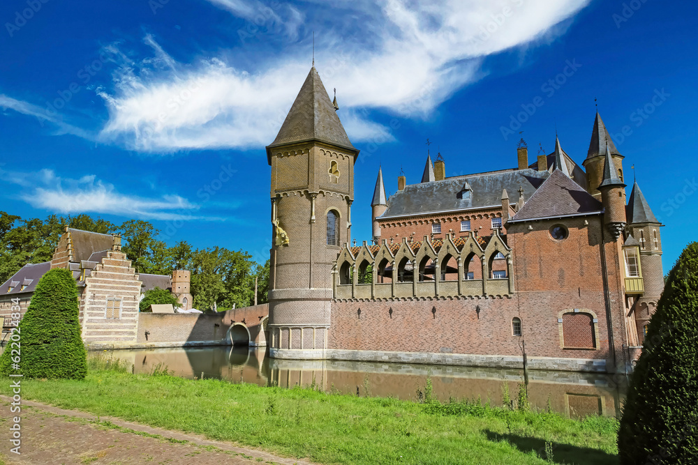 Beautiful dutch romantic fairy tale castle with towers, green garden park, blue summer sky - Kasteel Heeswijk, Netherlands
