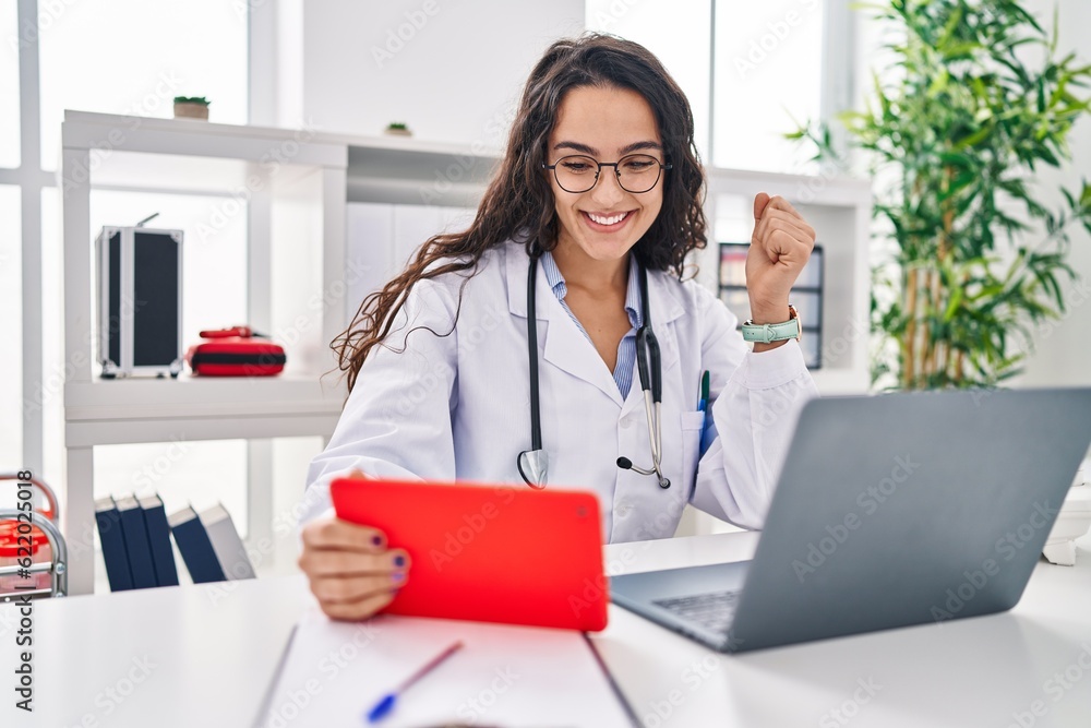 Young doctor woman working on online appointment screaming proud, celebrating victory and success very excited with raised arm Young doctor woman working on online appointment screaming proud, celebrating victory and success very excited with raised arm
