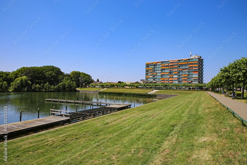 Beautiful swimming lake landscape on outskirts of city, jetties, green meadow, lakeside residential apartment house, cycle trail - Oosterplas den Bosch, S-Hertogenbosch