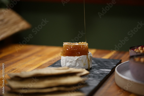 Konstfotografi Uma combinação irresistível: queijo brie derretido, acompanhado de um delicioso favo de mel e crocantes