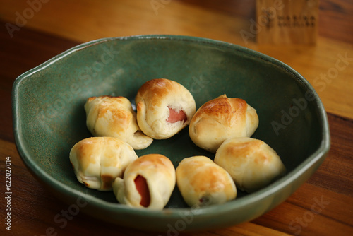 Deliciosos salgadinhos recheados de salsichas em um evento cheio de comidas gostosas. Uma opção irresistível para petiscar e aproveitar momentos especiais. photo