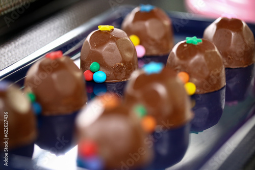 Deliciosos bombons de chocolate decorados com bolinhas coloridas, trazendo alegria e encanto à mesa de doces de uma divertida festa infantil. photo