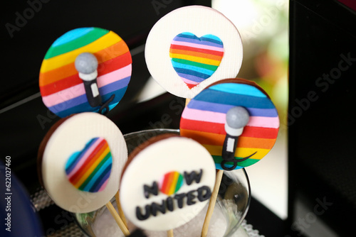 Alegria e cores se unem na decoração e na mesa de doces da festa inspirada no arco-íris. A frase 'Now United' ressalta a união e diversão deste evento encantador. photo
