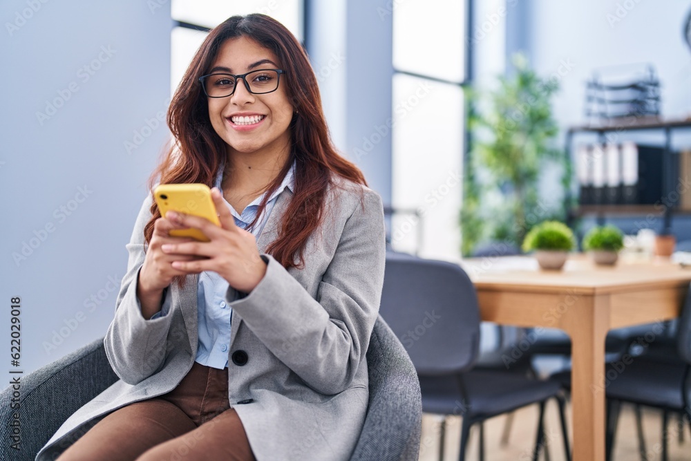 Young hispanic woman business worker using smartphone at office