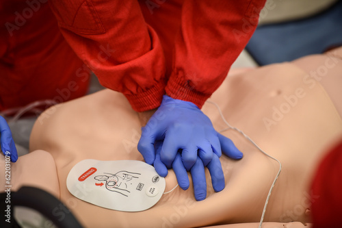 Paramedics simulate emergency intervention on medical training manikin photo