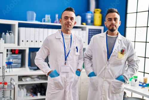 Two men scientists standing with relaxed expression at laboratory